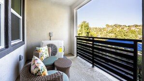 A balcony with wicker furniture, an air conditioning unit, and a view of a residential area. - Cozy Stay Near San Diego With 2 Car Garage (Lemon Grove)