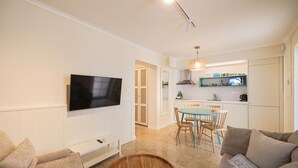 A modern living room with a flat-screen TV, a wooden coffee table, and a sofa. - Cozy apartment in Kukljica with WiFi (Kukljica)