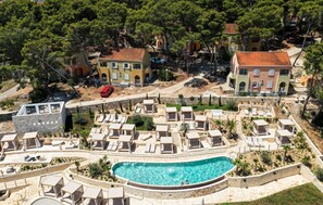 Ein Resort mit Pool, Liegestühlen und einem Steinhaus.