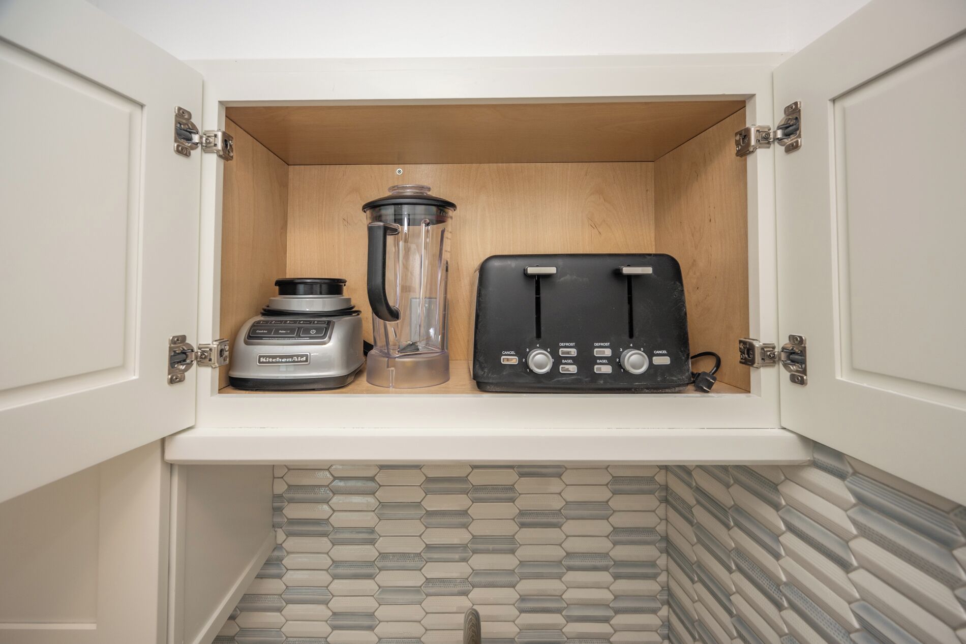 A kitchen cabinet with a built-in blender and toaster.