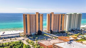 Ein Hochhaus-Hotel mit mehreren Etagen, Blick auf den Strand und einem Parkplatz.