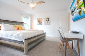 A bedroom with a bed, a desk, and a television. - Spacious 4BR Townhome w/ Private Pool • Storey Lake Resort • Near Disney (Kissimmee)
