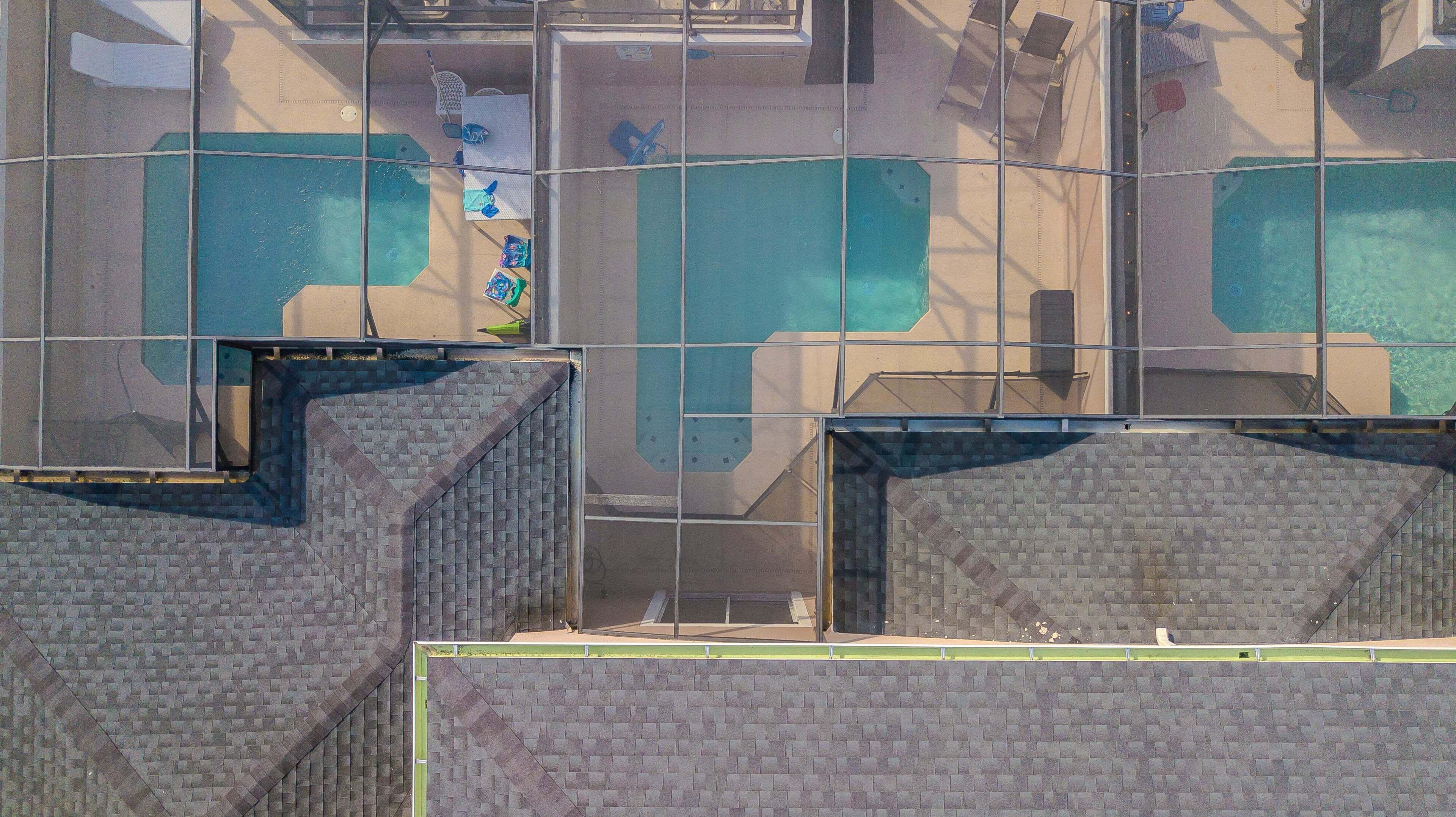 Un edificio con varias piscinas, fachada de ladrillo y cerramiento de vidrio.