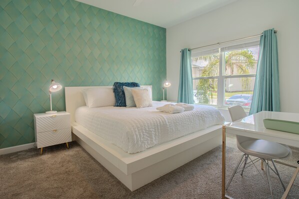 A bedroom with a bed, bedside tables, a desk, and a chair. - Family-Friendly 4BR Townhouse with Private Pool at Storey Lake Resort – Near Disney (Kissimmee)