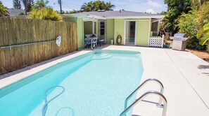 A backyard with a swimming pool, a wooden fence, and a small house with a door and windows. - Sunny Siesta Key Retreat w/ Private Heated Pool | 2BR | Dog-Friendly (Siesta Key)