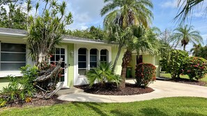 A residential property with a green exterior, a covered porch, and various tropical plants. - Sunny Siesta Key Retreat w/ Private Heated Pool | 2BR | Dog-Friendly (Siesta Key)