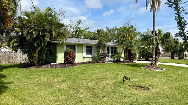 A residential property with a green house, a lawn, and various trees. - Sunny Siesta Key Retreat w/ Private Heated Pool | 2BR | Dog-Friendly (Siesta Key)