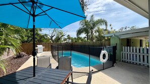 A backyard with a swimming pool, a barbecue grill, and a covered patio area. - Sunny Siesta Key Retreat w/ Private Heated Pool | 2BR | Dog-Friendly (Siesta Key)