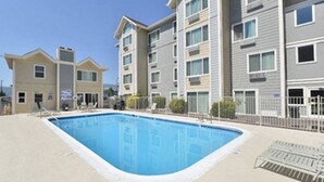 A multi-story residential building with a swimming pool. - Near Airport, Hospital, Midtown, 58 TV - Apt 254 (Reno)