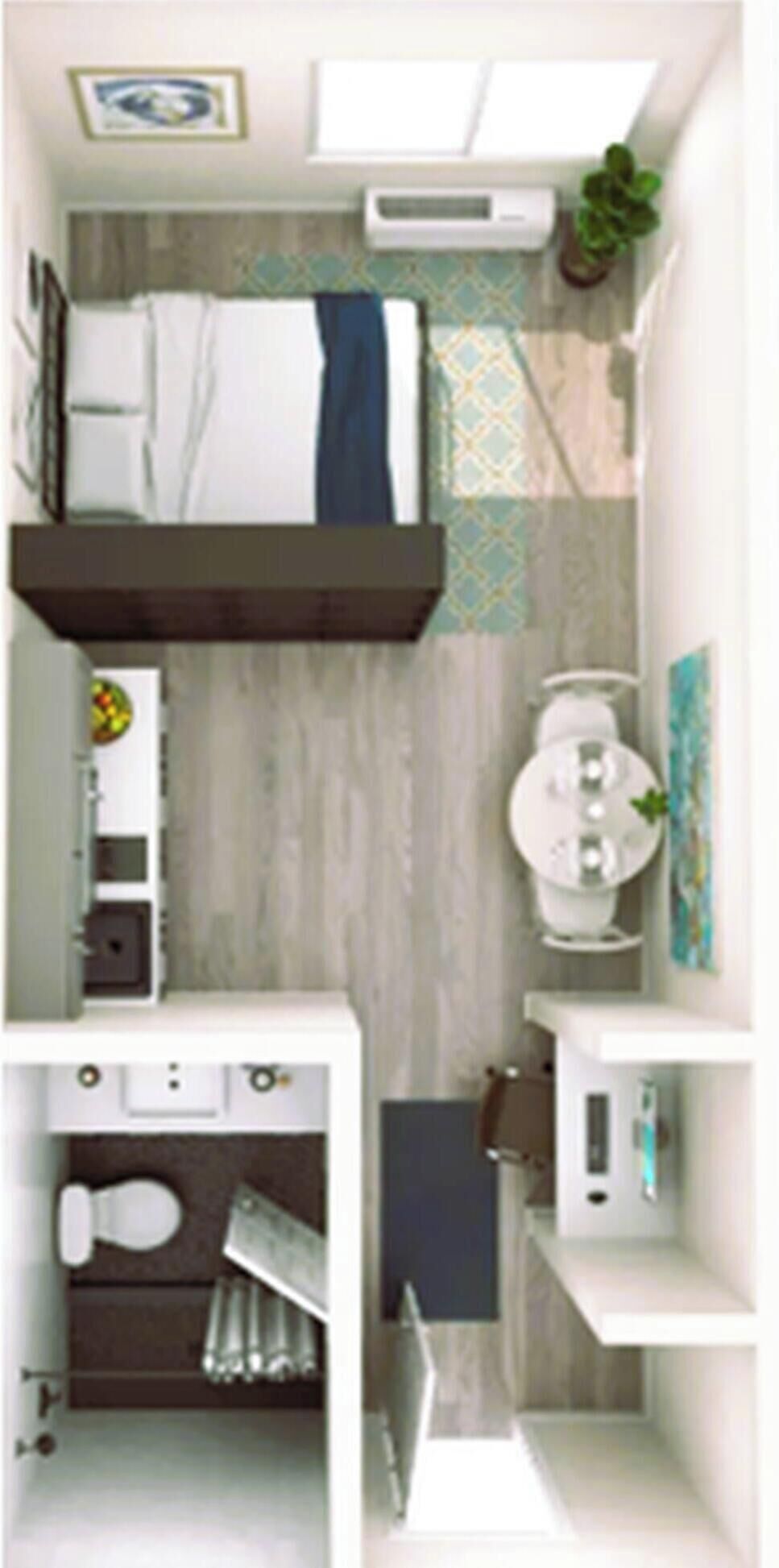 A compact hotel room with a bed, a small sitting area, a bathroom, and a kitchenette.