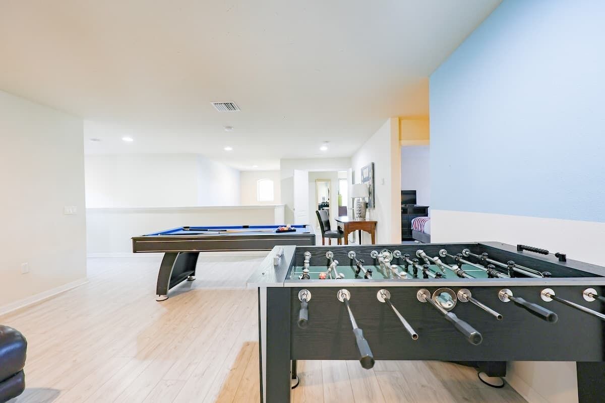 Une pièce équipée d’un baby-foot, d’une table de billard et d’une table de snooker.