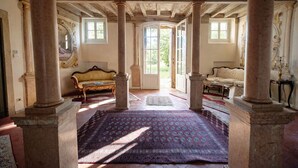 A room with a large patterned rug, two sofas, a table, and a view through an open door. - Villa Dorigny Dimora Storica (Verona)