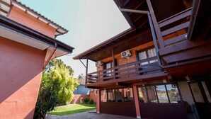 A two-story building with a balcony and a covered patio area. - Pousada Prime Gramado (Gramado)
