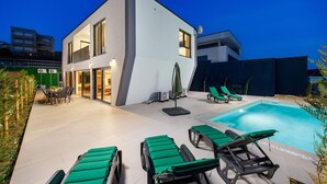 A modern two-story house with a swimming pool, outdoor seating, and a green lawn. - Nice home in Jadranovo (Jadranovo)