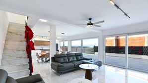 A spacious living area with a modern sofa, a dining table, and a balcony with a view. - Pet friendly home in Jadranovo with sauna (Jadranovo)