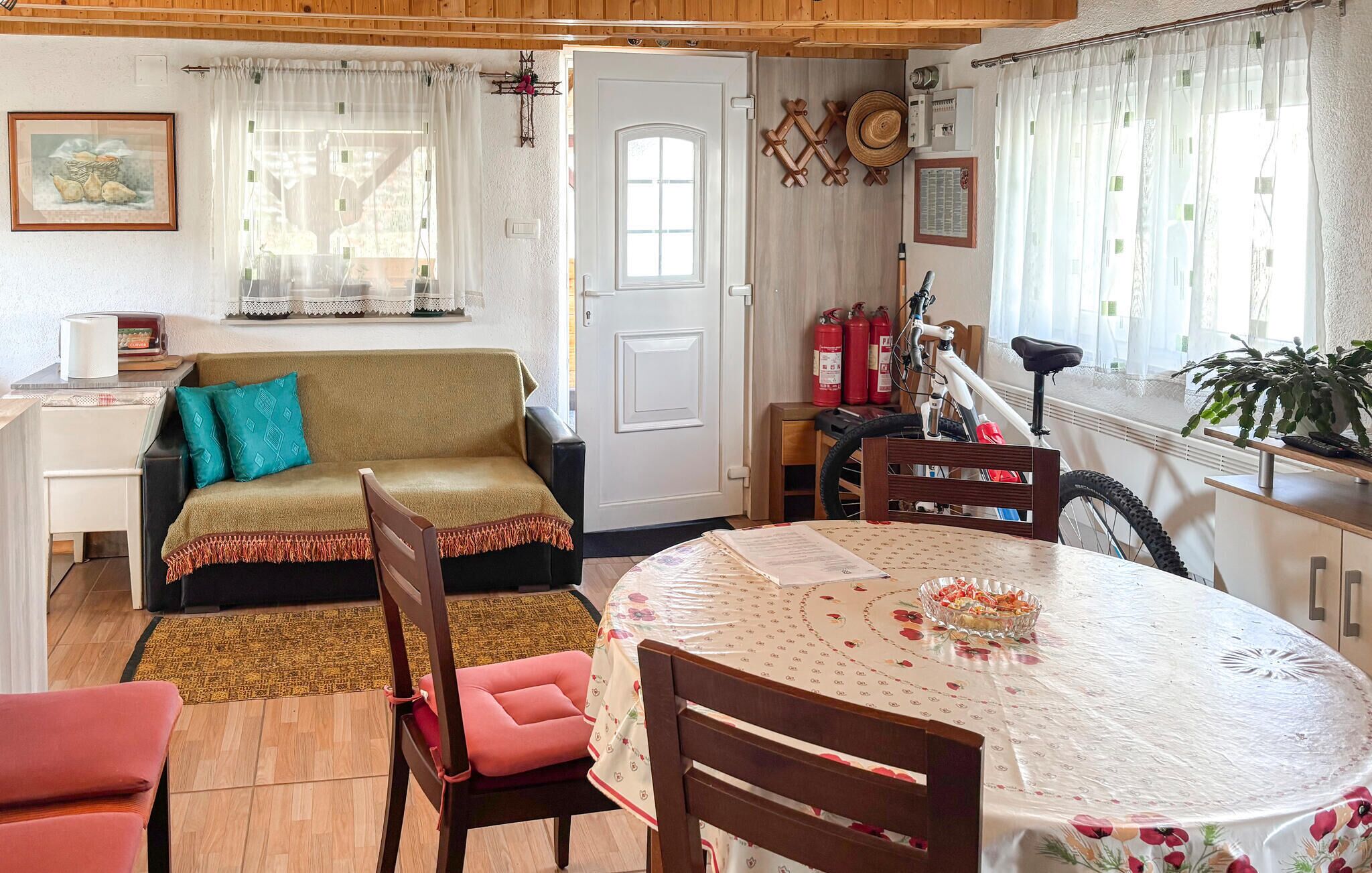A cozy living room with a sofa, a dining table, and a bicycle.