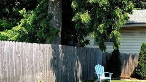 Un jardín con jardineras elevadas y una silla.