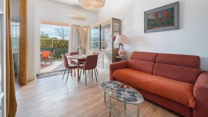 Ein modernes Wohnzimmer mit einer Couch, einem Esstisch, Stühlen und einem Glastisch.