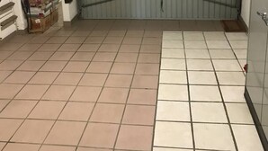 A garage with a bicycle rack, a closed garage door, and boxes on the floor. - ENSO - Studio Héliopolis J 4 + garage - Luxe - 2 people (AGDE)