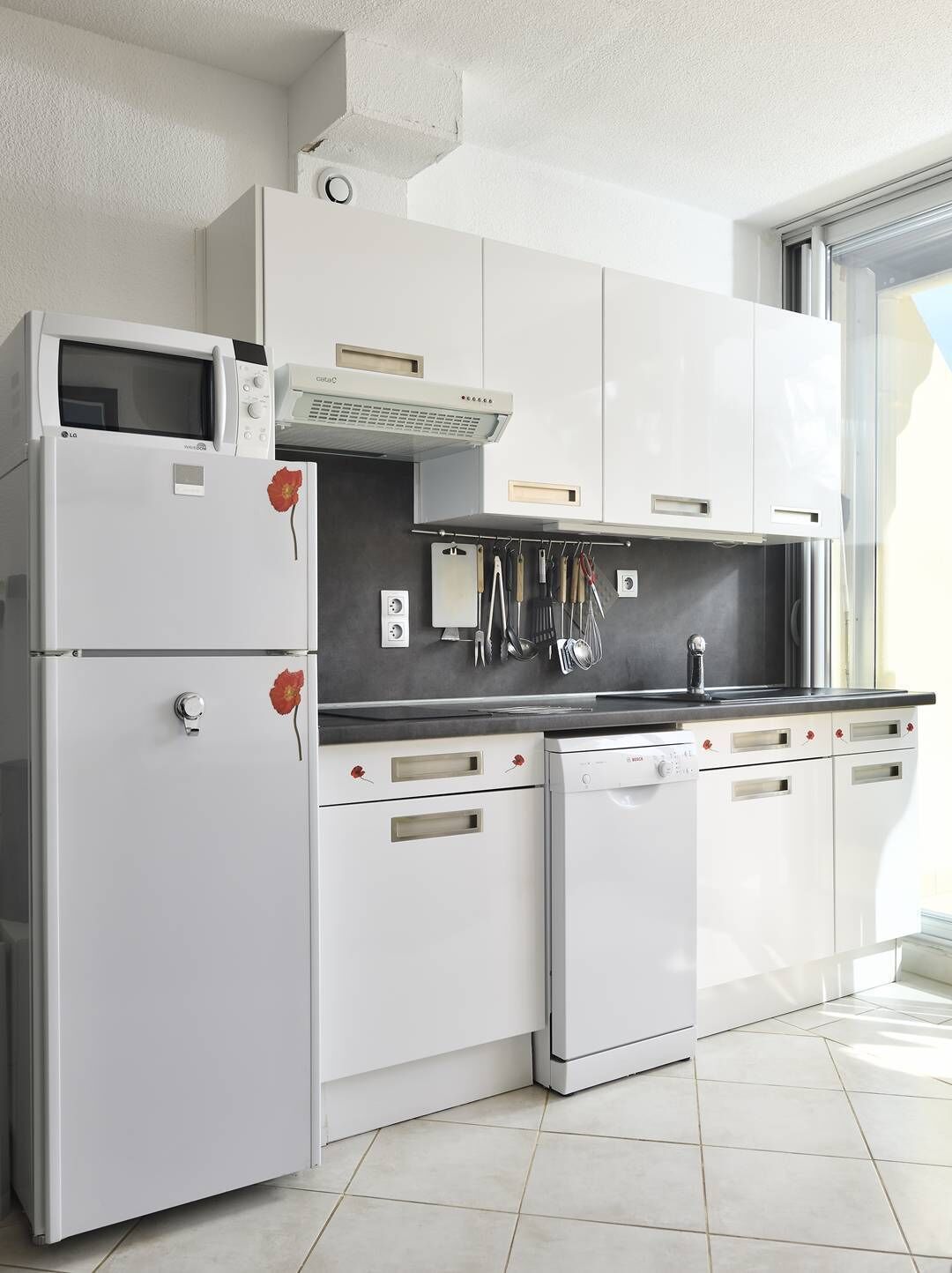 A modern kitchen with white cabinetry, a built-in microwave, and a dishwasher.
