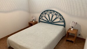 A single bed with a decorative headboard, two bedside tables, and a wall-mounted lamp. - Apartment Héliopolis J 42 - 5 people (AGDE)