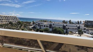 A balcony with a view of a coastal area, featuring modern buildings and a clear sky. - Apartment Héliopolis J 42 - 5 people (AGDE)