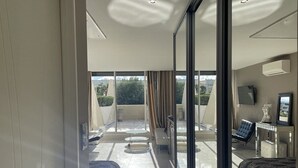 A modern hotel room with a balcony, a bed, a desk, and a chair. - KERYLOS - Studio Héliopolis K 3 with garage - Luxe - 2 people (AGDE)