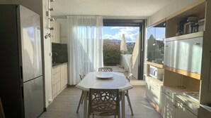 Une cuisine compacte comprenant une table et des chaises, un réfrigérateur et un four à micro-ondes.