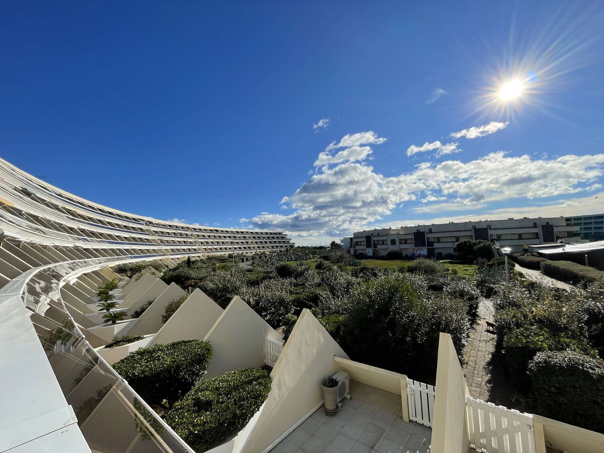 A modern hotel with a curved exterior and a rooftop garden.