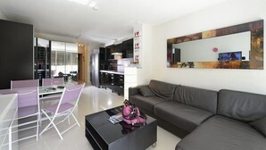 A modern living room with a grey sofa, a dining table with chairs, and a coffee table. - AMOUR AMOUR - Apartment Héliopolis K 209 - Luxe - 4 people (AGDE)