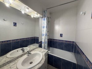 A bathroom with a double sink, a bathtub, and a shower curtain with star patterns. - PUZZLE - Studio Héliopolis L 86 - Classic - 4 people (AGDE)