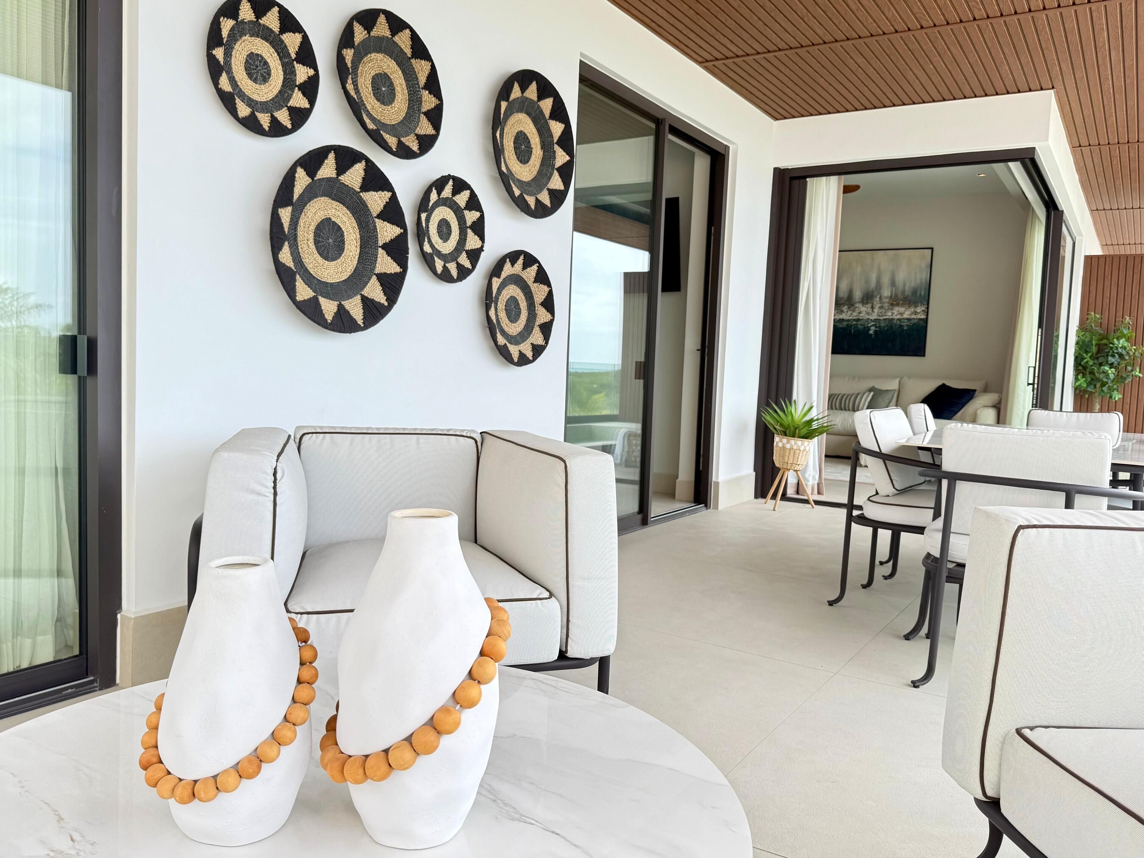 A modern living room with a sofa, two vases with wooden beads, and decorative wall art.