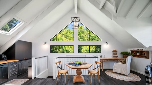 Cocina moderna con comedor, ventanas amplias y techo inclinado.