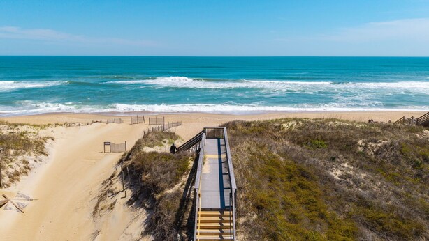 A beach with a wooden boardwalk leading to the shore, sandy beach, and ocean waves. - Rock Me on the Water: Oceanside, Pool, Hot Tub (Nags Head)