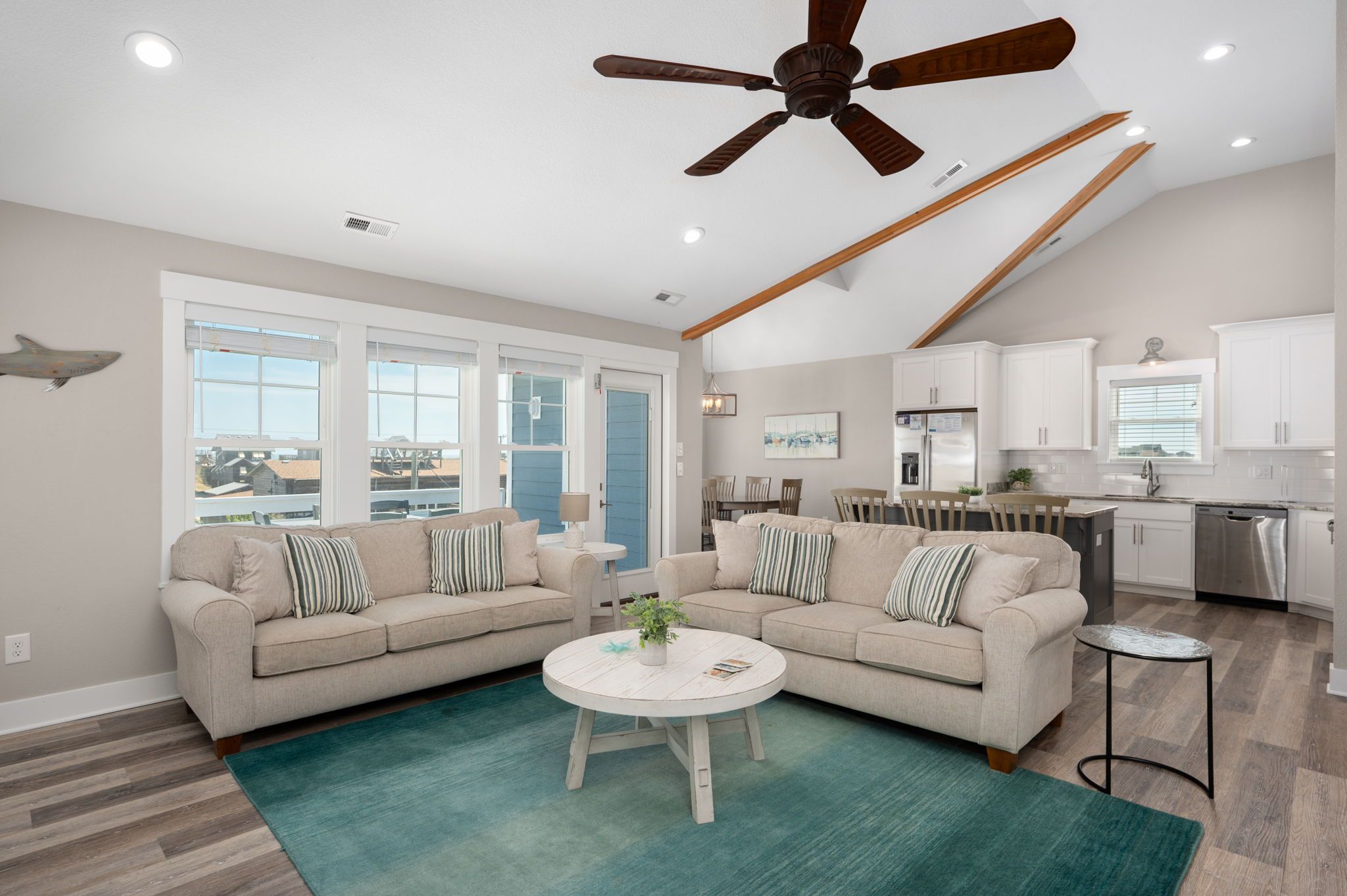 A spacious living room with two sofas, a coffee table, and a ceiling fan.