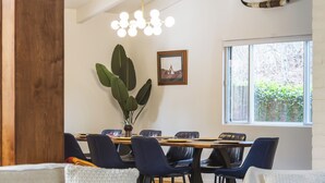 Un salon moderne avec un coin repas, comprenant un canapé, des fauteuils, une table basse et une table à manger avec des chaises.