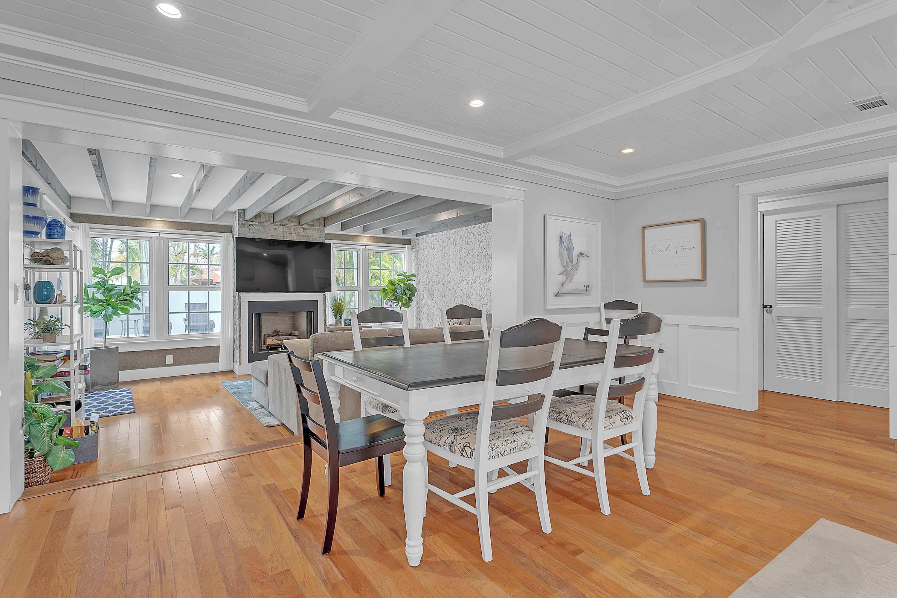 A dining area with a wooden table and chairs, a fireplace, and a view of the outdoors.