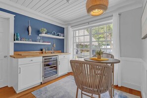 A kitchen with white cabinets, a wooden countertop, a built-in oven, and a window with a view of palm trees. - Tropical Oasis w/ Private Pool & Tiki Bar (Deerfield Beach)