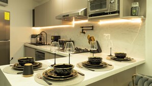 A modern kitchen with a microwave, stove, and various kitchen utensils. - Mary's Villas  (Oranjestad)