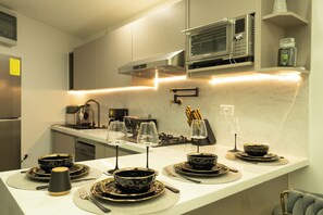 A modern kitchen with a microwave, stove, and various kitchen utensils. - Mary's Villas  (Oranjestad)