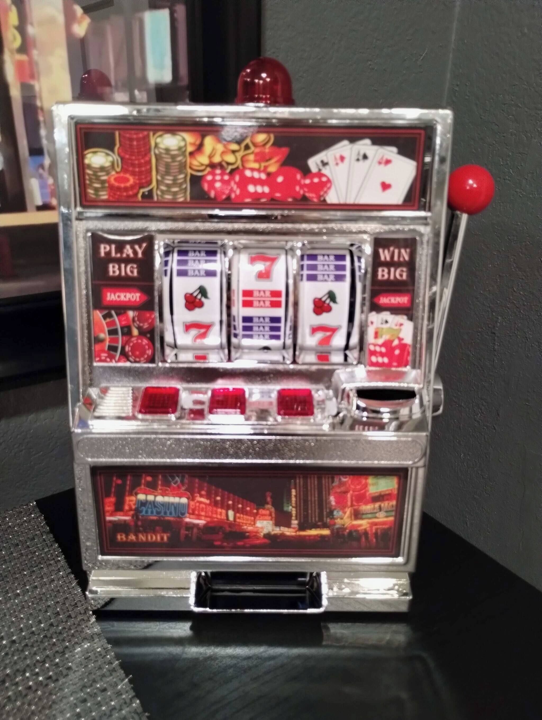 A slot machine with "PLAY BIG" and "WIN BIG" labels, a jackpot symbol, and a "BAR" symbol on each reel.