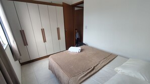 Une chambre à coucher avec un lit, une grande armoire et une porte donnant sur une autre pièce.