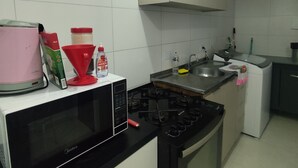 Une cuisine équipée d’un four à micro-ondes, d’une cuisinière, d’un évier et de placards.