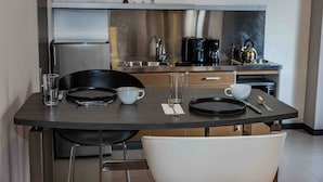 A modern kitchen with stainless steel appliances, a dining table with chairs, and a coffee maker. - 617 Living  (Bogotá)