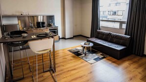 A compact living space with a kitchenette, a sofa, a dining area, and a window with curtains. - 617 Living  (Bogotá)