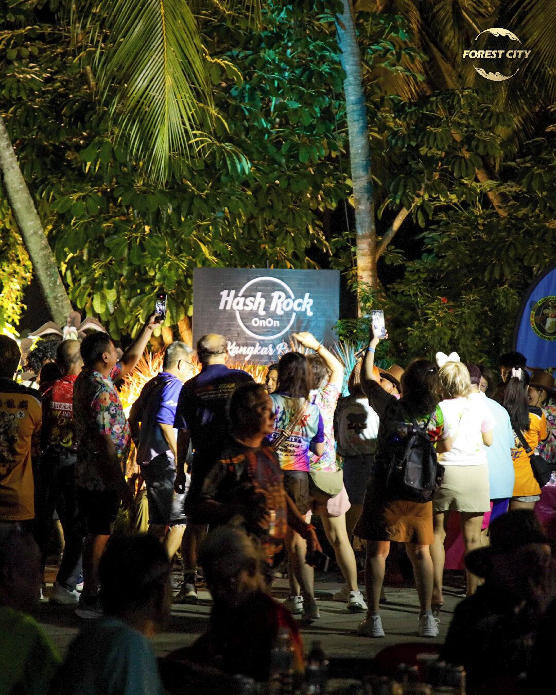 A crowd at an outdoor event with a banner reading "Hash Rock OnOn".