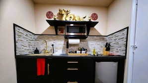 A compact kitchen with a microwave, sink, and storage cabinets. - Asian Zen With Jacuzzi, Kitchenette, Near Victoria Sq (Sparks)