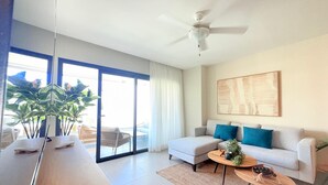 Ein modernes Wohnzimmer mit einer Couch, einem Couchtisch und einem Deckenventilator.