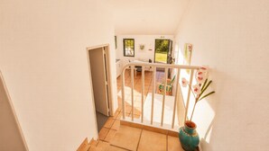 Eine Treppe führt zu einem Balkon mit Blick ins Freie.