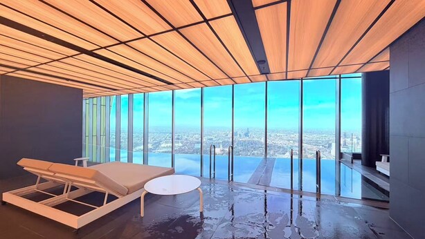 A modern room with a large window, a massage table, and a small round table. - Modern 1-bedroom apartment with gym and pool access, centrally located near cafes, restaurants, and public transport—perfect for a comfortable city stay. (Southbank)
